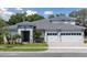 Attractive single-Gathering home with manicured lawn, neutral paint, a gray roof, stone accents and a three-car garage at 4517 Foley Grove Dr, Valrico, FL 33596