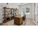 Well-lit office space with a wooden desk, chair, and shelving at 4517 Foley Grove Dr, Valrico, FL 33596