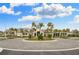 A beautiful clubhouse with tropical landscaping in a paved roundabout entrance at 4931 Sevilla Shores Dr, Wimauma, FL 33598
