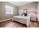 Cozy bedroom with hardwood floors, a large window, and a nightstand at 5132 Pinnacle Dr, Oldsmar, FL 34677