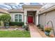 Welcoming front entrance with a brick walkway leading to a vibrant red double-door entry at 5132 Pinnacle Dr, Oldsmar, FL 34677