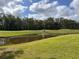 Scenic golf course with a water feature and a golf cart in the distance at 5132 Pinnacle Dr, Oldsmar, FL 34677