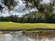 Beautiful golf course with green grass, sand trap and a pond in the foreground at 5132 Pinnacle Dr, Oldsmar, FL 34677