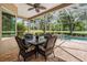 Inviting screened-in patio with wicker furniture, perfect for enjoying outdoor dining and relaxing near the pool at 5132 Pinnacle Dr, Oldsmar, FL 34677