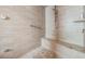 Walk-in shower featuring travertine tile, a built-in seat, and a mounted shower head at 5132 Pinnacle Dr, Oldsmar, FL 34677