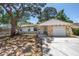 Charming single-story home with stone accents, a well-manicured lawn, and mature shade trees at 518 62Nd Ne Ave, St Petersburg, FL 33702