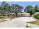 Inviting single-story home with a front-facing garage, landscaped lawn and mature trees casting shade at 518 62Nd Ne Ave, St Petersburg, FL 33702