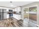 Bright kitchen with white cabinets, stainless steel appliances, and sliding glass doors to the yard at 518 62Nd Ne Ave, St Petersburg, FL 33702