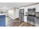 Updated kitchen features stainless steel appliances, white cabinetry and wood look flooring at 518 62Nd Ne Ave, St Petersburg, FL 33702