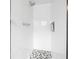 White tiled shower with patterned floor, contrasting black niche, and modern shower head at 518 62Nd Ne Ave, St Petersburg, FL 33702