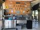 Outdoor bar area featuring stainless steel cabinets, sink, mini fridge, and rustic wood wall at 5341 Circle Dr, Weeki Wachee, FL 34607