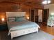 Bedroom featuring a king bed, wooden floors, wood paneled walls, and natural light at 5341 Circle Dr, Weeki Wachee, FL 34607