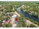 Aerial view of a home nestled among mature trees and lush surroundings near a calm river at 5415 Park Pl, Tampa, FL 33603