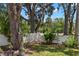 A charming front yard with lush greenery, mature trees, and a white block fence at 5415 Park Pl, Tampa, FL 33603