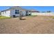 Wide view of a backyard with white fencing, a covered patio, and a small tree at 5464 Flint Hills Dr, Wimauma, FL 33598