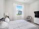Bedroom features a ceiling fan, a large window, and a TV on a dresser at 5464 Flint Hills Dr, Wimauma, FL 33598