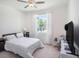 Bright bedroom with a large window, a ceiling fan, and a small rocking chair at 5464 Flint Hills Dr, Wimauma, FL 33598