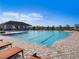Community pool with lounge chairs and a pool house, perfect for relaxing on sunny days at 5464 Flint Hills Dr, Wimauma, FL 33598