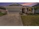 Charming single-story home with well-maintained lawn and a two-car garage at sunset at 5464 Flint Hills Dr, Wimauma, FL 33598