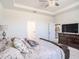 Spacious main bedroom featuring tray ceilings, a ceiling fan, and a dark wood dresser at 5464 Flint Hills Dr, Wimauma, FL 33598