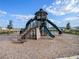 Community playground with slides and climbing structures set on a wood chip surface at 5464 Flint Hills Dr, Wimauma, FL 33598
