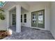 Charming front porch with stone flooring and beautiful green doors leading into the home at 5717 Tybee Island Dr, Apollo Beach, FL 33572