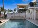 Stunning backyard with a pool, stone waterfall, a spiral staircase, and tropical landscaping at 5820 Balao S Way, St Pete Beach, FL 33706