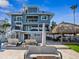 Backyard view of a multi-story home, pool, tiki bar, and outdoor seating area for relaxation and entertainment at 5820 Balao S Way, St Pete Beach, FL 33706