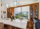 Stylish bar area with wood cabinetry, a marble countertop, and a scenic view from the window at 5820 Balao S Way, St Pete Beach, FL 33706