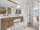 Modern bathroom vanity with white countertop, stylish drawers and adjacent entrance showcasing view of waterfront at 5820 Balao S Way, St Pete Beach, FL 33706
