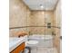 Well-lit bathroom with a glass-enclosed tub-shower combination and stylish fixtures at 5820 Balao S Way, St Pete Beach, FL 33706