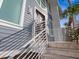 Beautiful home exterior showcasing a blue facade, white railings, and decorative wooden front doors at 5820 Balao S Way, St Pete Beach, FL 33706
