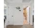 Hallway with bathroom door ajar, neutral walls, and hardwood floors showing views to rooms with water views at 5820 Balao S Way, St Pete Beach, FL 33706