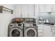 Well-equipped laundry area with stainless steel appliances and ample storage in white cabinets at 5820 Balao S Way, St Pete Beach, FL 33706