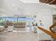 Open-concept living area with waterfront views, tile floors, modern staircase, and neutral decor at 5820 Balao S Way, St Pete Beach, FL 33706