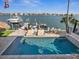 Beautiful waterfront home featuring a private pool, boat dock with lifts, and outdoor dining area at 5820 Balao S Way, St Pete Beach, FL 33706