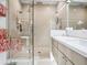 Bright bathroom featuring frameless shower, wall-mounted showerheads, and vanity with white countertop and modern drawers at 5820 Balao S Way, St Pete Beach, FL 33706