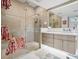 Main bathroom with walk-in glass shower and neutral vanity with double sinks at 5820 Balao S Way, St Pete Beach, FL 33706