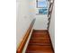 A carpetless wooden staircase with decorative glass ascends to the upper level of the home at 5820 Balao S Way, St Pete Beach, FL 33706