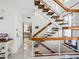 Modern staircase with wood treads and glass railings, complemented by a view into the kitchen at 5820 Balao S Way, St Pete Beach, FL 33706