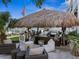 Outdoor tiki bar with seating, a grill, and a plush lounge area for relaxing by the waterfront pool at 5820 Balao S Way, St Pete Beach, FL 33706