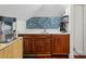 A stylish wet bar features dark wood cabinetry, a white countertop, and a blue mosaic tile backsplash at 5820 Balao S Way, St Pete Beach, FL 33706