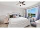 This primary bedroom features a ceiling fan and view of the lake outside the window at 6206 Mooring Line Cir, Apollo Beach, FL 33572