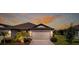 Home exterior with a two-car garage and cozy landscaping highlighted against the sunset at 6206 Mooring Line Cir, Apollo Beach, FL 33572