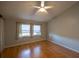 Bedroom featuring hardwood floors, a ceiling fan, and two windows for natural light at 6438 Brentwood Dr, Zephyrhills, FL 33542