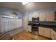 Cozy kitchen featuring stainless appliances, light colored cabinetry, and an arched window at 6438 Brentwood Dr, Zephyrhills, FL 33542