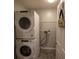 Efficient laundry room with stacked washer and dryer units and storage shelves at 6438 Brentwood Dr, Zephyrhills, FL 33542