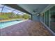 Outdoor patio area with brick flooring, ceiling fan, sliding glass doors, and view of the pool and backyard at 6440 Maiden Sea Dr, Apollo Beach, FL 33572