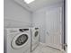 Functional laundry room with modern Samsung washer and dryer, white cabinets and shelving at 6440 Maiden Sea Dr, Apollo Beach, FL 33572