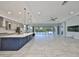 Bright open-concept living space with kitchen island, tile flooring, and sliding glass doors to the pool area at 6440 Maiden Sea Dr, Apollo Beach, FL 33572